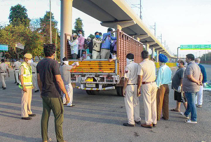 Migrants board a truck to their native village, during a nationwide lockdown imposed in the wake of coronavirus pandemic, in Faridabad. (PTI Photo)