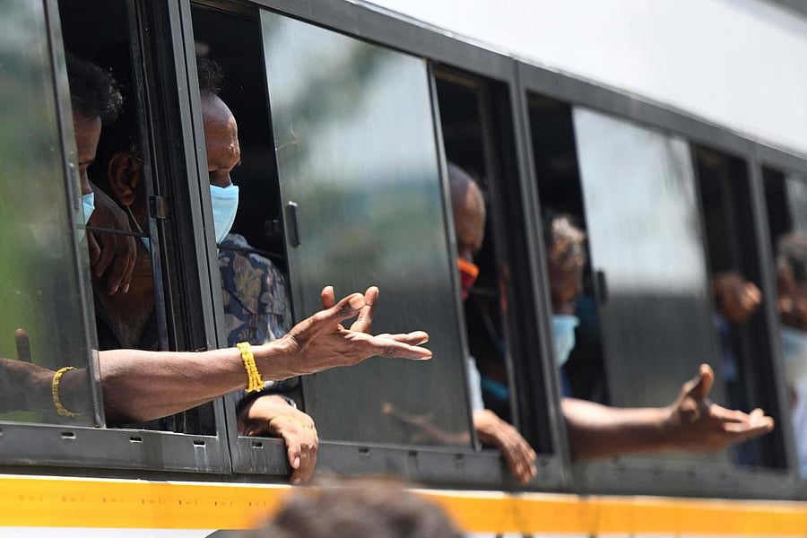 Migrant worker and stranded travellers wave through a window of a bus as they leave to their hometowns after the government eased a nationwide lockdown imposed as a preventive measure against the COVID-19 coronavirus, in Chennai. AFP