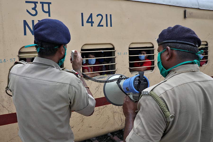 Police officers make announcements as a train carrying migrant workers, who were stranded in the western state of Rajasthan (Reuters Photo)