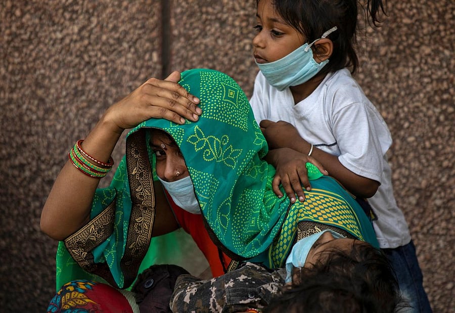 A migrant family waits to get registered before boarding a train to their home state of eastern Bihar, during an extended lockdown to slow the spreading of the coronavirus disease (COVID-19), in New Delhi, India, May 21, 2020. REUTERS/Danish Siddiqui