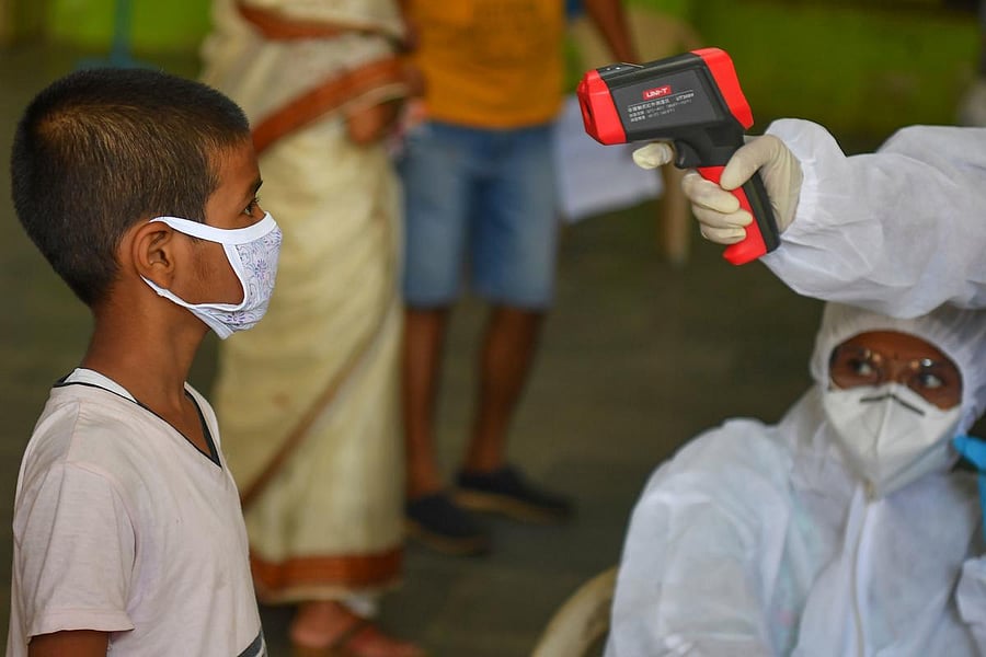 Medical staff take the temperature of a child at a COVID-19 coronavirus community clinic during a nationwide lockdown imposed as a preventive measure against the COVID-19 coronavirus, in Mumbai. (AFP Photo)