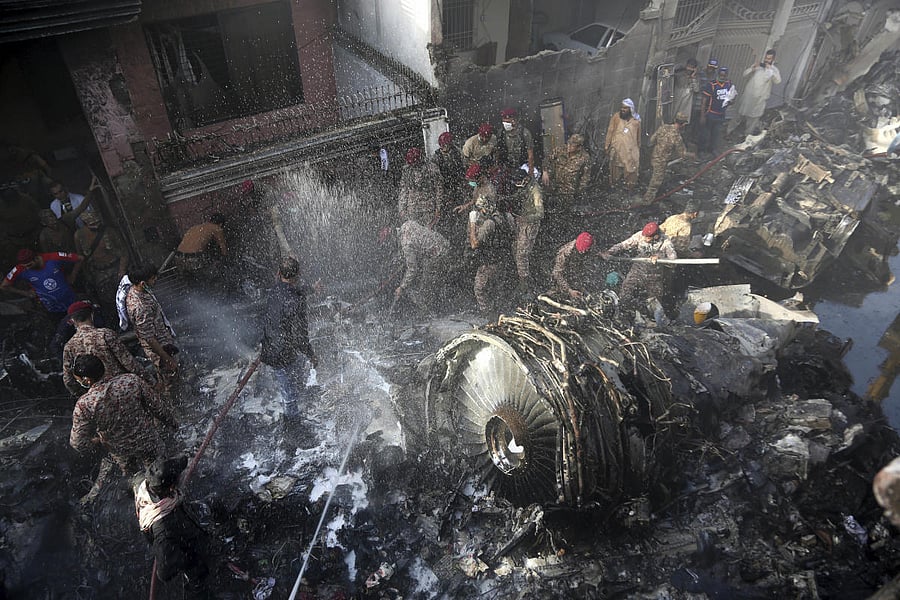 Volunteers look for survivors of a plane that crashed in residential area of Karachi, Pakistan, May 22, 2020. Credit: AP Photo