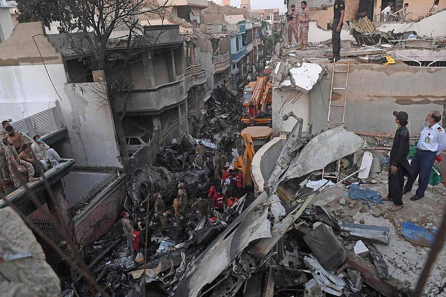  Security personnel search for victims in the wreckage of a Pakistan International Airlines aircraft after it crashed in a residential area in Karachi. (AFP Photo)
