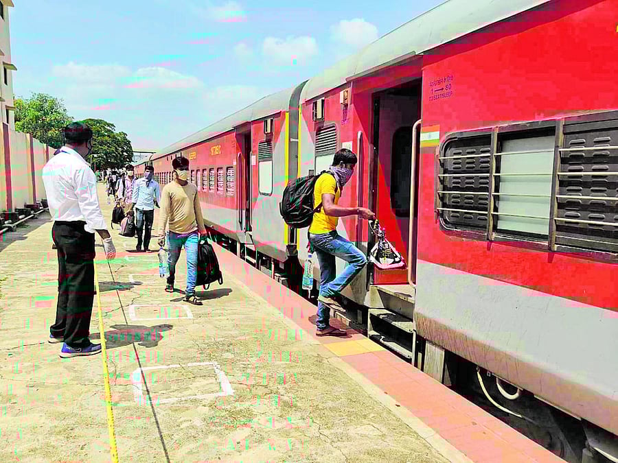 Migrant workers from Bihar board train at Ashokapuram Railway Station in Mysuru on Sunday.