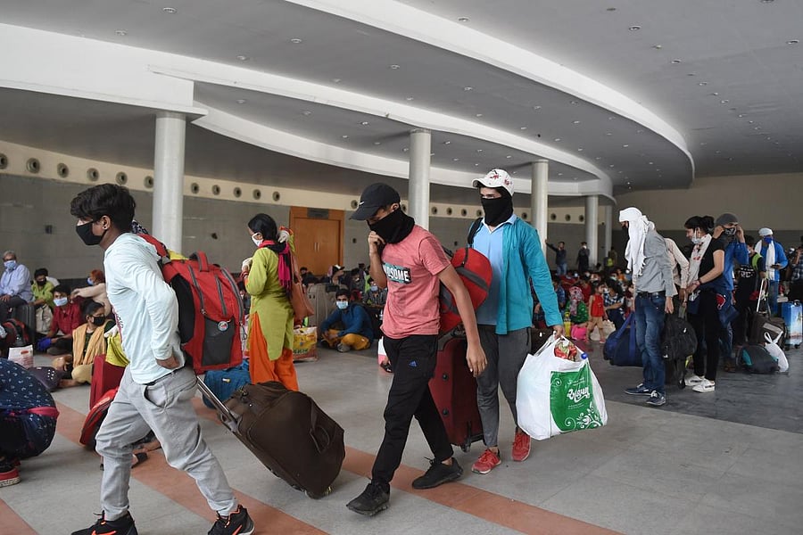 Stranded migrant workers queue to board buses taking them to a railway station to take special train services (AFP Photo)