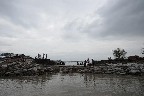 Volunteers and residents work to repair a damaged dam following the landfall of cyclone Amphan in Burigoalini on May 21, 2020. (Credit: AFP Photo)