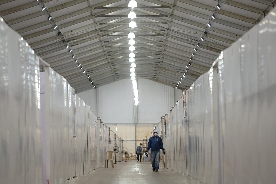A man wearing a protective face mask walks through the corridor of a hospital that has been constructed to treat patients who test positive for the coronavirus disease. Reuters