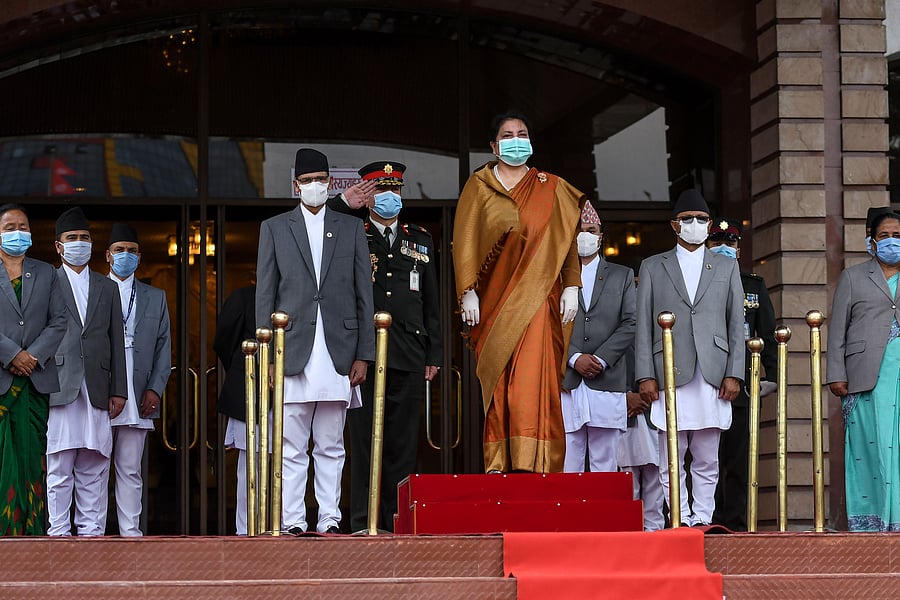 Nepal's President Bidhya Devi Bhandari (C) stands as she listens to the national anthem on her arrival at the parliament to present the new government's programme for the fiscal year 2020/2021 in Kathmandu. (Credit: AFP Photo)