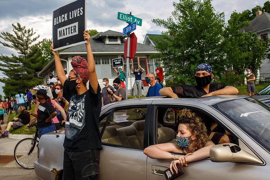 People hold signs and protest after a Minneapolis Police Department officer allegedly killed George Floyd. (AFP Photo)