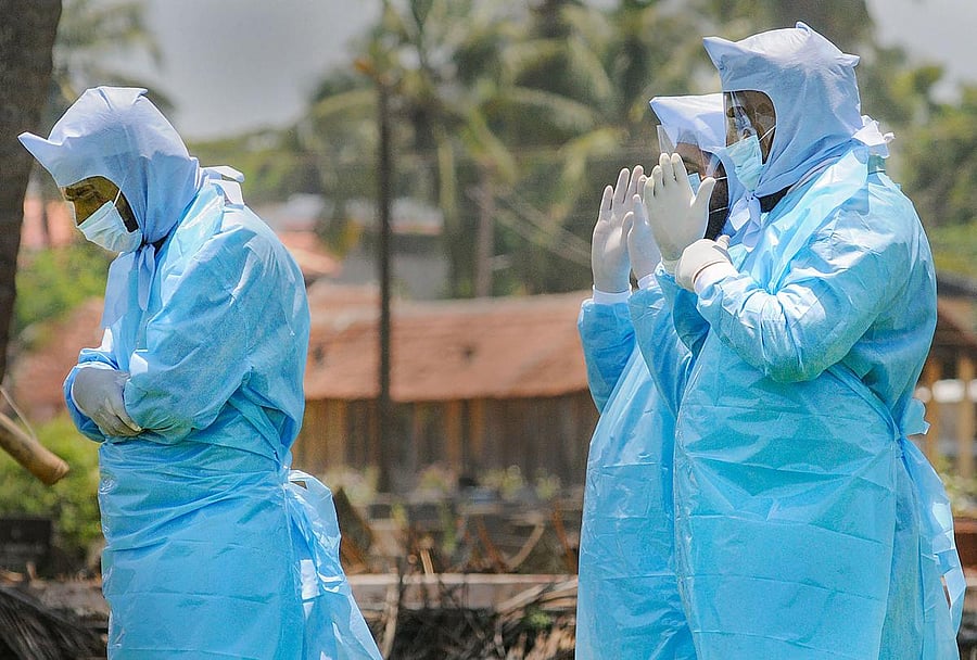 Family members, in protective suits, pray before receiving the body of the COVID-19 victim Ayisha (62) for funeral at Kannamparamba in Kozhikode, Tuesday, May 26, 2020. (PTI Photo)