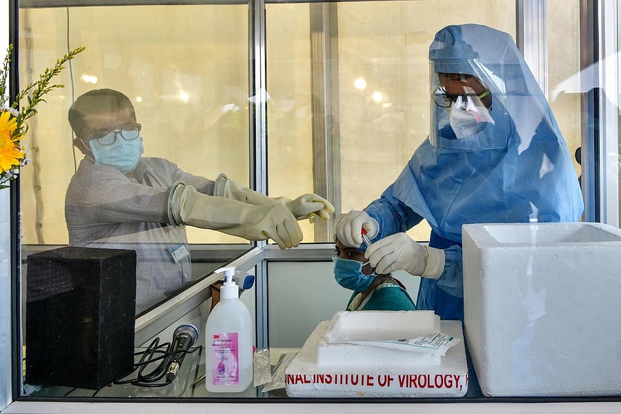 Medical professionals give a demonstration of the smart screening kiosk introduced to fight against the COVID-19 coronavirus during its launch event at the Vidhana Soudha in Bangalore. (AFP Photo)