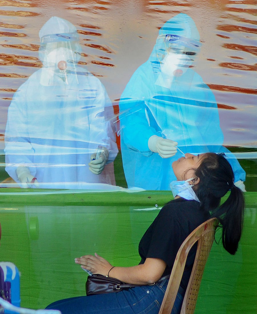 Medics check a passenger on her arrival at Mohanbari Airport from Kolkata, following the resumption of domestic flight operations, during ongoing COVID-19 lockdown in Dibrugarh. (AFP Photo)