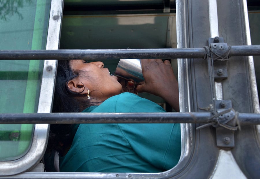 A migrant drinks water onboard a bus. (PTI Photo)