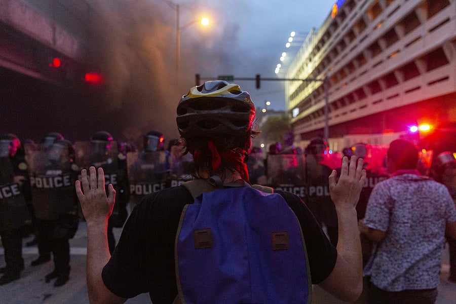 A protest holds up his hands in front of a row of riot police during a protest against police brutality in Miami. (AFP Photo)
