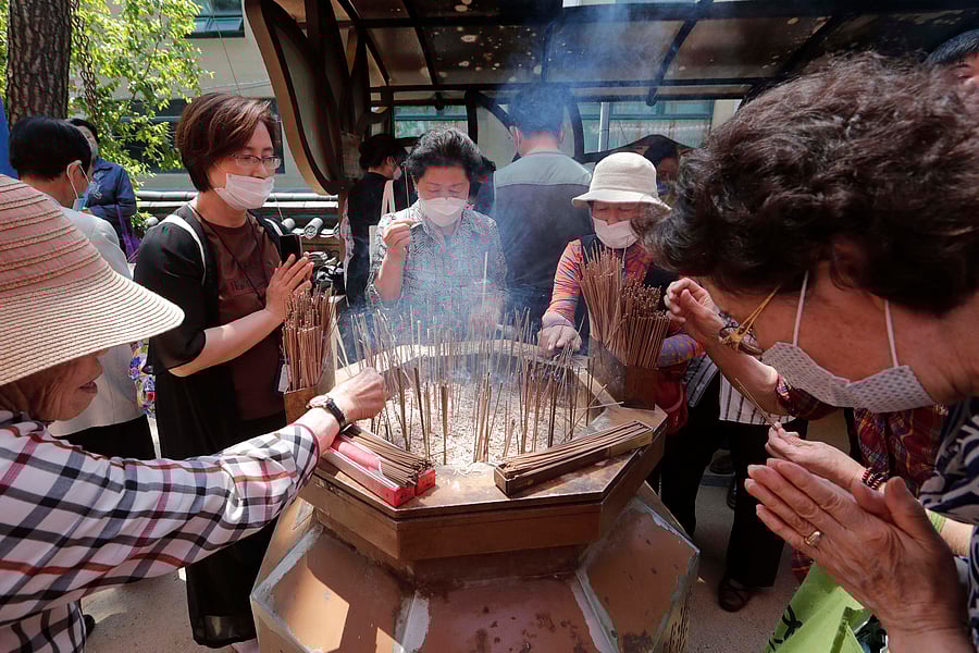 Buddhist believers pray as they place incense after the Buddha's birthday ceremony at the Jogye temple in Seoul, South Korea. (AP Photo)