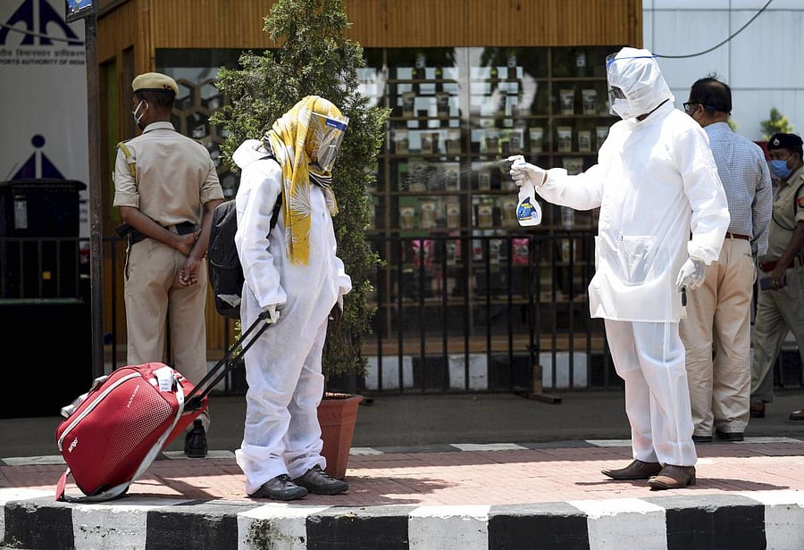  A worker sprays disinfectant on a passenger who arrived at Lokpriya Gopinath Bordoloi International Airport for domestic travel, following the resumption of domestic flight services after a gap of two months, during the ongoing COVID-19 lockdown, in Guwahati. (PTI Photo)