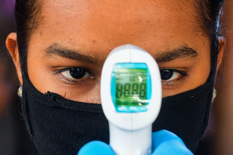 A resident gets her temperature tested at a screening centre set up inside a slum during a nationwide lockdown to fight the spread of the COVID-19 coronavirus, in Mumbai. (AFP Photo)