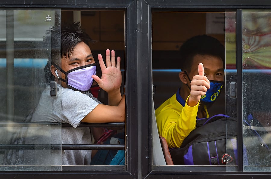 Migrants from Manipur wave from a bus while going to the Central Railway Station to catch a special train for their native places, during ongoing COVID-19 lockdown. (PTI Photo)