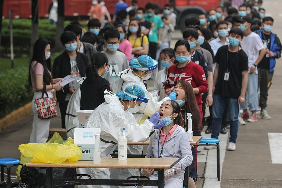 This file photo taken on May 15, 2020 shows a medical worker taking a swab sample from a staff member from the AOC computer monitor factory to be tested for the COVID-19 coronavirus in Wuhan in China's central Hubei province. Credit: AFP Photo