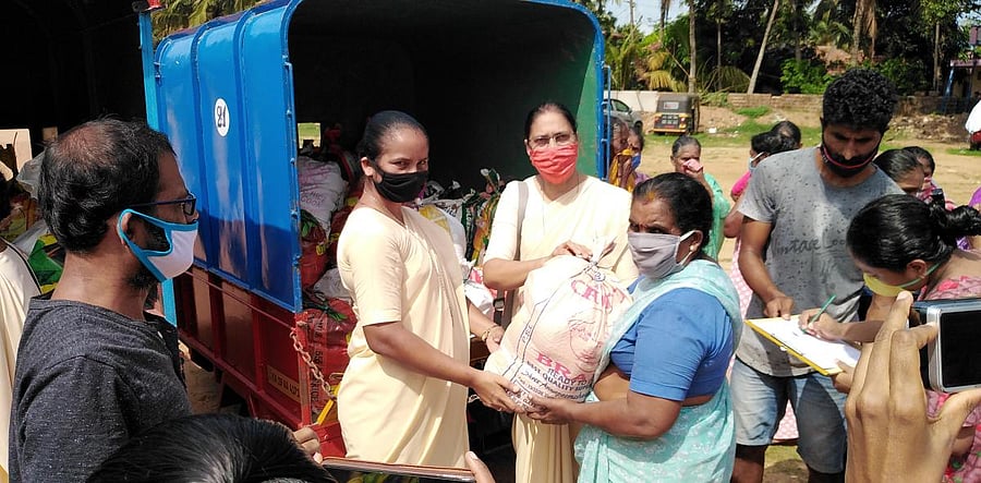 (First from right) Ursuline Franciscan Sisters (UFS), Deralakatte, Assistant Superior General Sr Milly Fernandes distributed ration kits to migrant fishermen families at Hoige Bazar in Bolar.