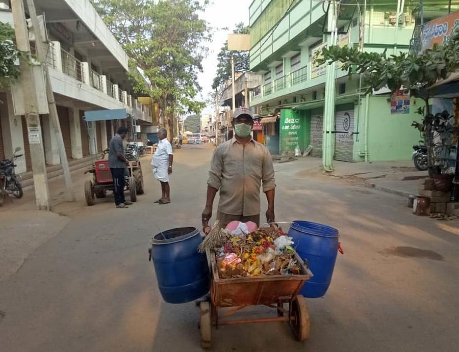 Phalakshaiah collects garbage from a road at Maruti Layout in Malur town in Kolar district. DH Photo