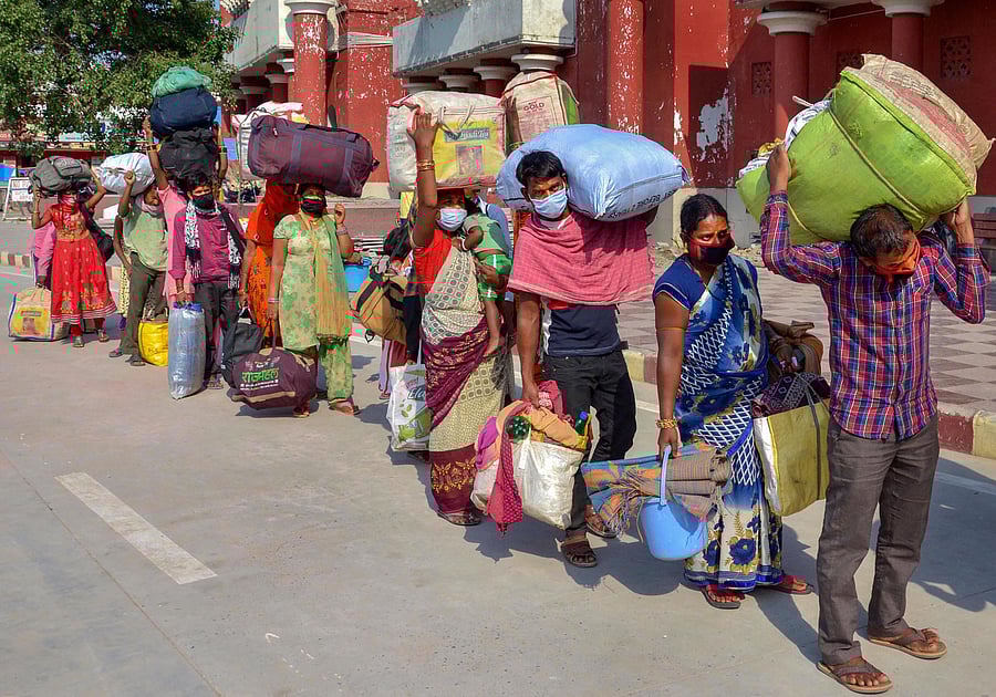 Migrants from Chhattisgarh stand in a queue as they arrive at Amritsar Railway station to board a special train to return to their native places, during the ongoing COVID-19 lockdown. Credit: PTI Photo