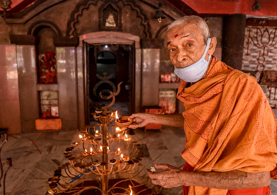 A priest offers prayers at Ugratara temple after the authorities permitted opening of all religious places with certain restrictions. Credit: PTI Photo