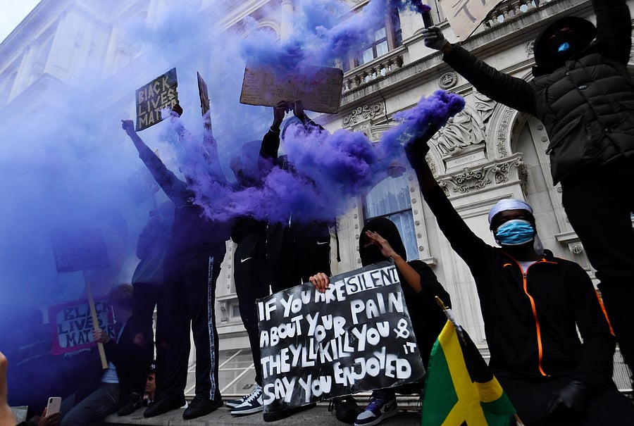 Demonstrators hold up signs and flares in Parliament Square during a Black Lives Matter protest in London, following the death of George Floyd who died in police custody in Minneapolis, London, Britain. Credit/Reuters Photo