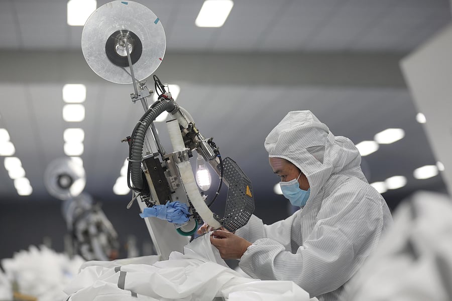An employee works on a production line manufacturing protective suits at a medical supply factory in Xinzhou district of Wuhan. Credit: Reuters
