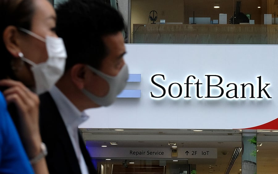 Pedestrians walk past a Japan's SoftBank mobile shop in Tokyo. Credits: AFP Photo