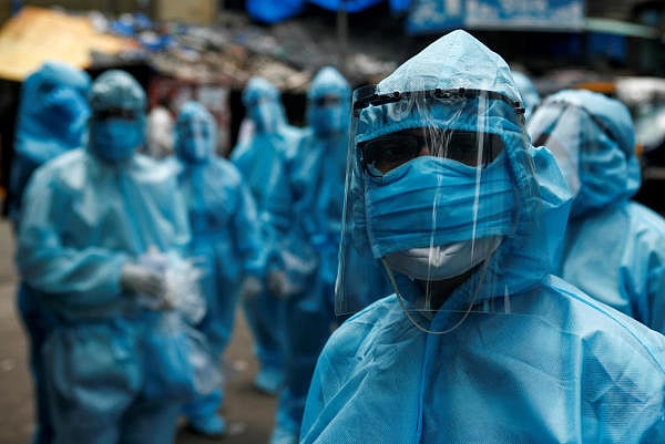 Healthcare workers wait to take off their personal protective equipment (PPE) after the end of a check-up camp for the coronavirus disease (COVID-19) at a slum in Mumbai, India June 14, 2020. Credit: Reuters Photo