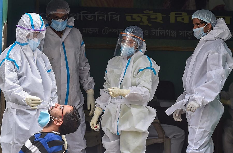 A health worker collects swab sample of a person for COVID-19 test at a center, during the nationwide lockdown, in Kolkata, Wednesday, June 17, 2020. Credit/PTI Photo