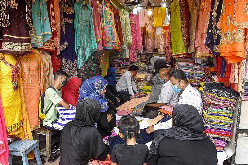 alesmen show garments to customers at a clothing store, during the ongoing COVID-19 nationwide lockdown, in Bhopal. Credits: PTI Photo