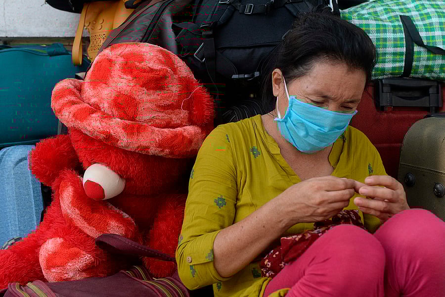 A stranded migrant labourer sits at an assembling centre to get transferred to railway station to board on a special train to Mizoram. Credits: AFP Photo