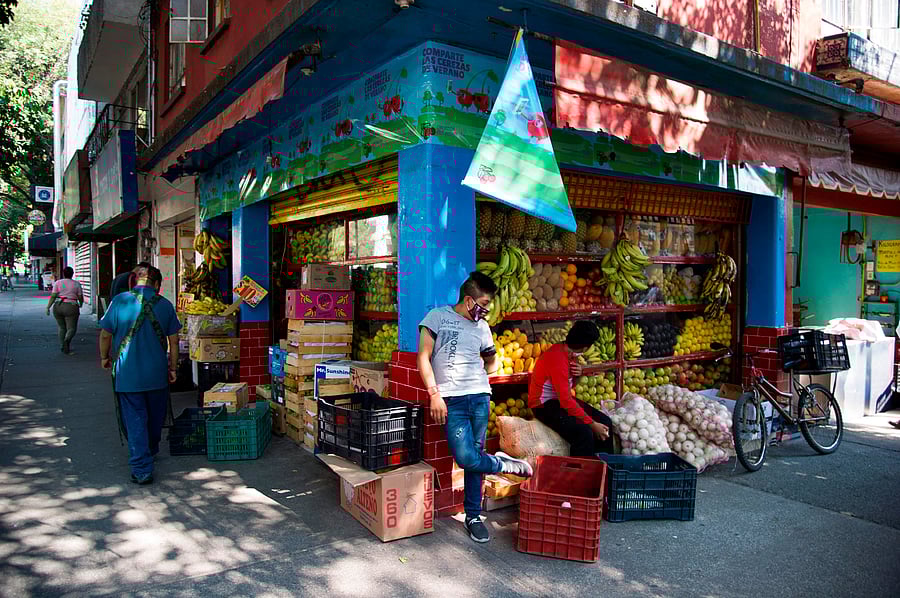Youth wearing protective masks wait for customers at a greengrocery in Mexico City. Credit: AFP Photo
