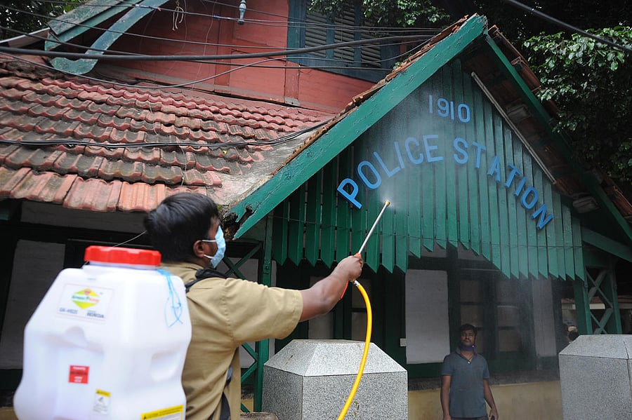 A health worker sprays disinfectant at the Cubbon Park police station in Bengaluru on Saturday. A total of six policemen in the city tested positive for Covid-19 in a single day. DH Photo/Pushkar V