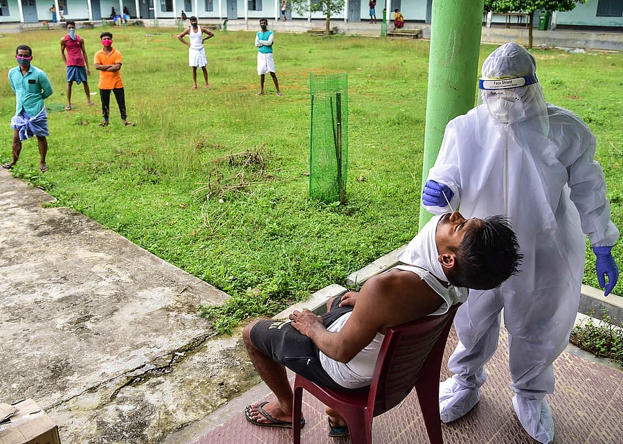 A medic collects samples for COVID-19 swab test from a migrant labor returning from Kerala state, during the ongoing COVID-19. Credits: PTI Photo