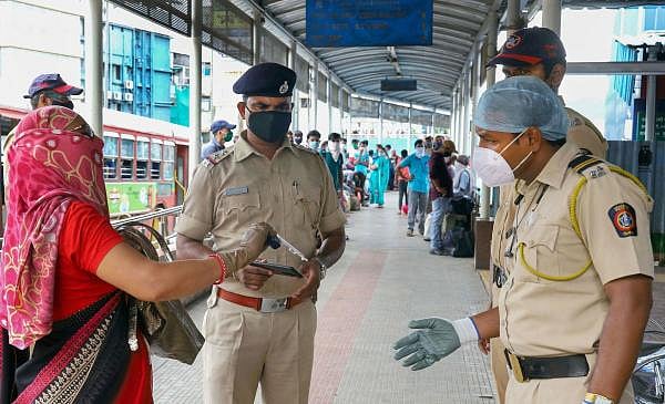 Police personnel check an ID of a woman at a station, after local trains resumed but only for people in essential services, amid the ongoing COVID-19 nationwide lockdown, in Thane. Credit: Reuters