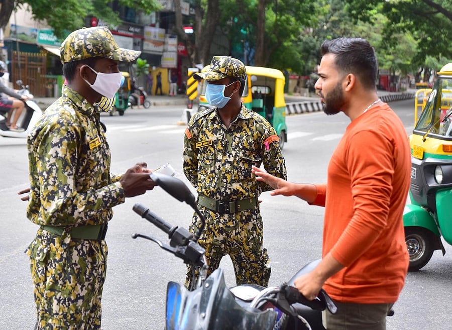 A motorist is penalised for not wearing mask in Bengaluru on Sunday. DH Photo/Anup Raghu T