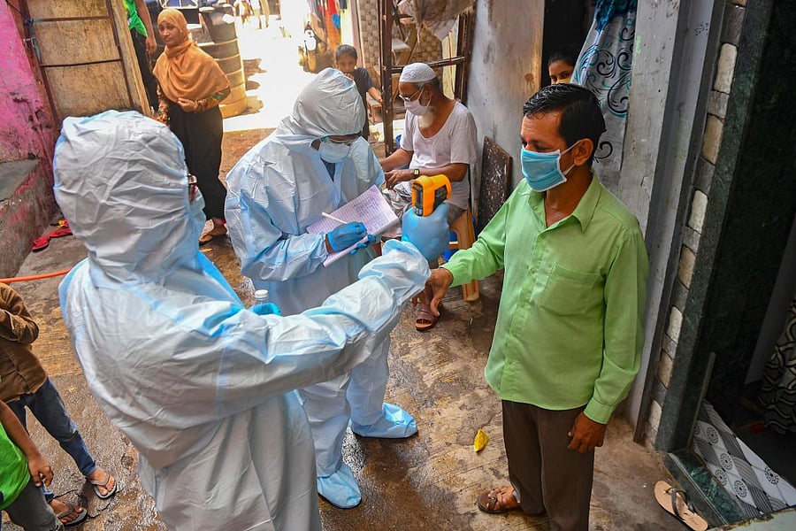Medical staff wearing Personal Protective Equipment (PPE) gear conduct a door-to-door medical screening (AFP Photo)