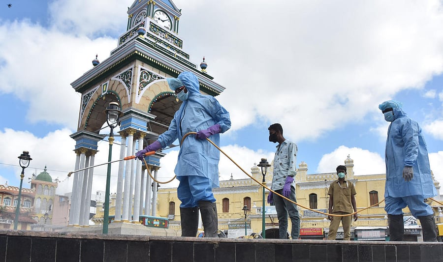 Workers spray disinfectant at Chikka Gadiyara in Mysuru on Thursday. DH PHOTO
