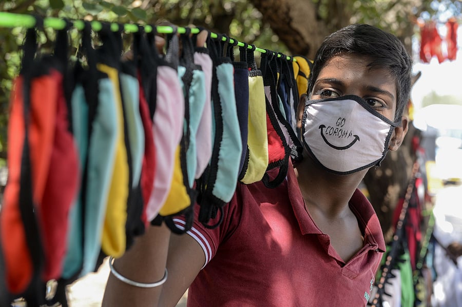 A street vendor arranges facemasks to sell on the roadside as a preventive measure against the spread of the Covid-19. Credits: AFP Photo