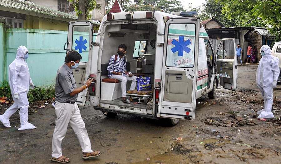 A suspected COVID-19 patient, wearing a mask, sits inside an ambulance before being taken to Gauhati Medical College and Hospital (GMCH) for treatment at Uzanbazar, during nationwide COVID-19 lockdown, in Guwahati, Friday, June 12, 2020. Credit/PTI Photo