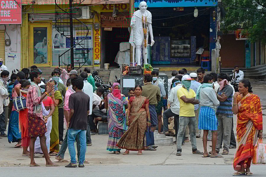 Construction labourers stand along the roadside as they wait to be hired for daily wages after the government eased a nationwide lockdown imposed as a preventive measure against the Covid-19, on the outskirts of Hyderabad. Credits: AFP Photo