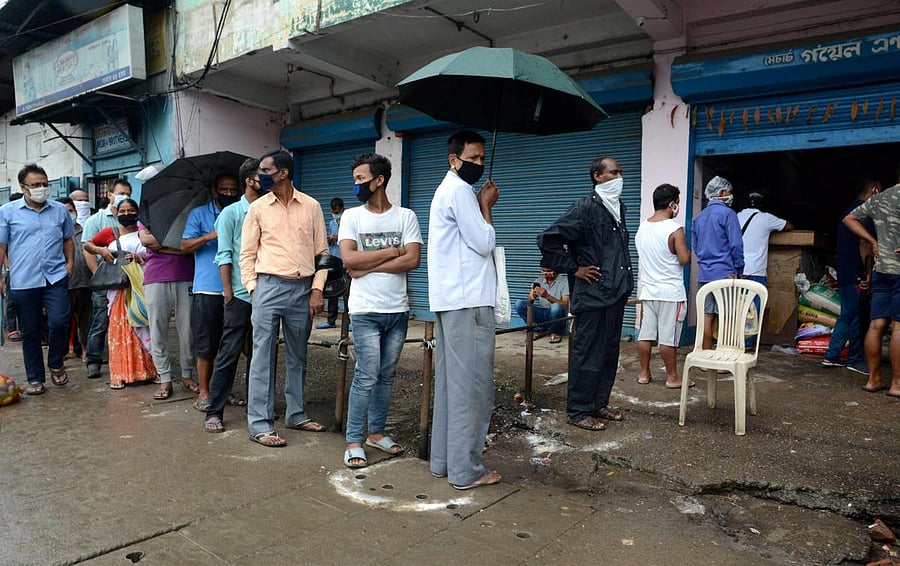 People stand in a queue to buy essentials from a shop after the state government declared complete lockdown from June 28 to curb the spread of coronavirus disease, in Guwahati, Saturday, June 27, 2020. Credit/PTI Photo