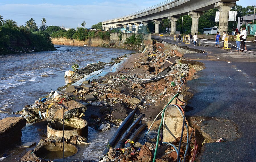 Thursday’s downpour not only brought down the Vrishabhavathi retaining wall but also washed away a part of Mysuru Road. Credits: DH Photo