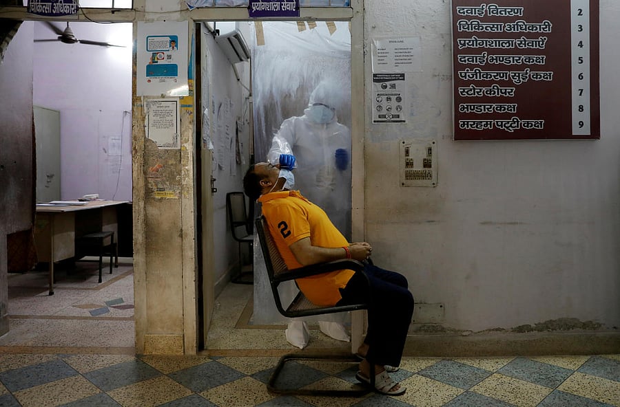 A health worker in personal protective equipment (PPE) collects a sample using a swab from a person at a local health centre to conduct tests for the coronavirus disease (COVID-19), amid the spread of the disease, in New Delhi. Credit: Reuters