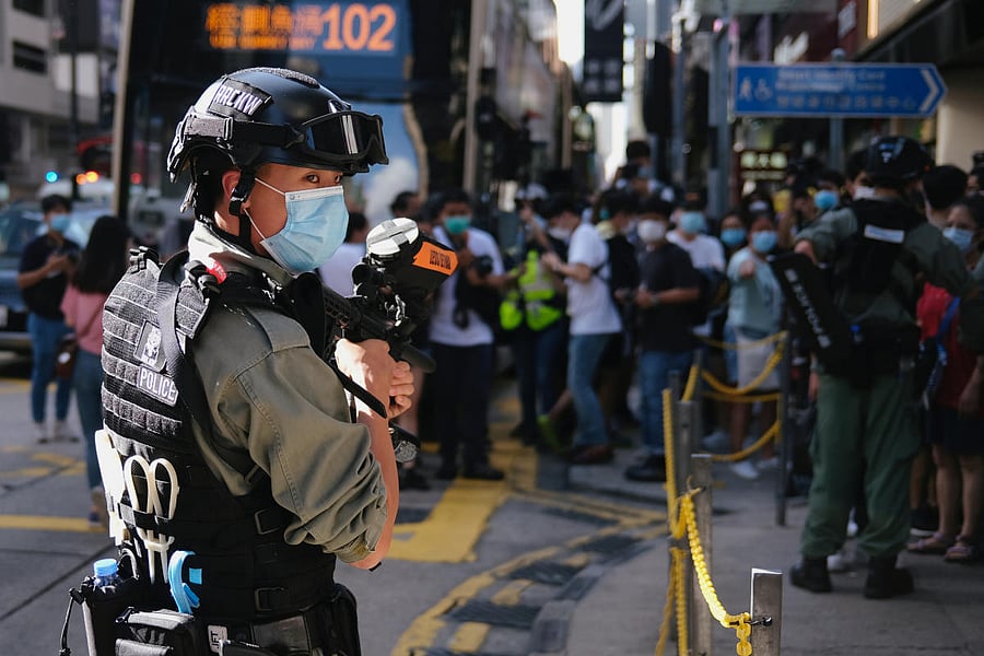 A riot police officer holds a pepper-spray projectile as he stands guard to avoid mass gathering during a protest against the looming national security legislation in Hong Kong (Reuters Photo)