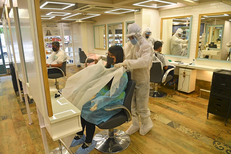 Staff at Shiva's Signature hair salon wearing Personal Protective Equipment (PPE) suits and face shields attend customers after personal grooming services were allowed to resume following relaxation of lockdown norms amidst Covid-19 coronavirus pandemic, in Mumbai on June 28, 2020. Credit/AFP Photo