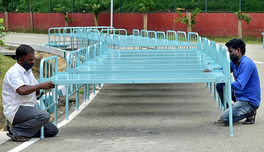 Just before the BBMP ditched Kanteerava as a Covid centre, workers were busy fixing hospital beds there. DH PHOTO/RANJU P